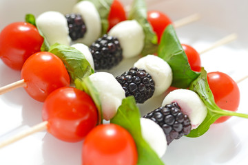 Tomato cherry, blackberries and mozzarella skewers as appetizers