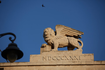 statue of lev against the sky and under his paw book