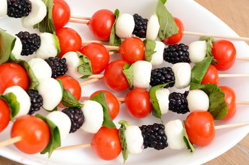 Tomato cherry, blackberries and mozzarella skewers as appetizers