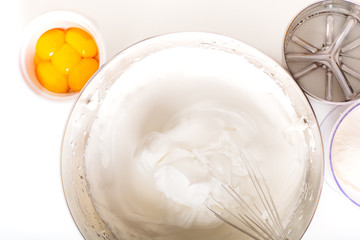 Baking bakery concept whipped eggs mix with ingredients for homemade sponge cake on white background