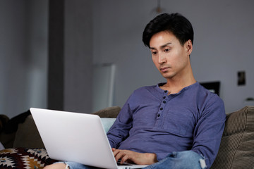 Asian Man Working Laptop Home Connecting Networking Concept.