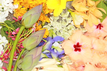 Beautiful bouquet of mixed colorful flowers on concrete floor.Vibrant bright mixed indian flowers. hibiscus,lotus,jasmine,champak,allamanda,marigold, butterfly pea. background on full screen.