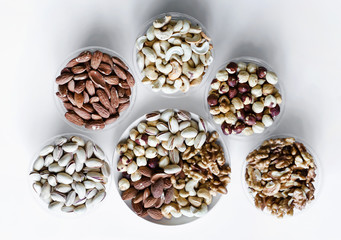Healthy food. Nuts mix assortment on white grey table top view. Collection of different legumes for background image close up nuts, pistachios, almond, cashew nuts, peanut, walnut. image