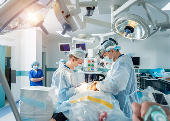 Spinal surgery. Group of surgeons in operating room with surgery equipment. Laminectomy