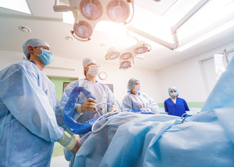 Arthroscope surgery. Orthopedic surgeons in teamwork in the operating room with modern arthroscopic...