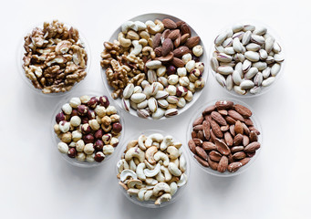 Healthy food. Nuts mix assortment on white grey table top view. Collection of different legumes for background image close up nuts, pistachios, almond, cashew nuts, peanut, walnut. image