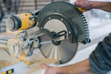 Worker cuts a wooden beam circular saw.