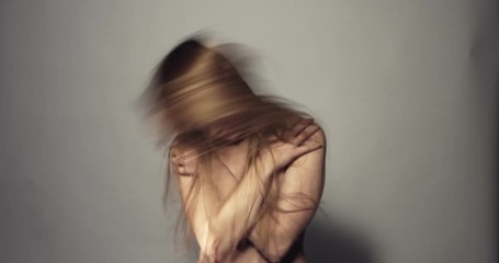 Woman with mental illness throwing her head and long hair.
