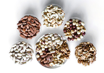 Healthy food. Nuts mix assortment on white grey table top view. Collection of different legumes for background image close up nuts, pistachios, almond, cashew nuts, peanut, walnut. image