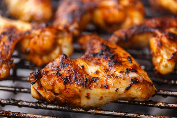 Chicken wings on barbecue, BBQ grill with fire.