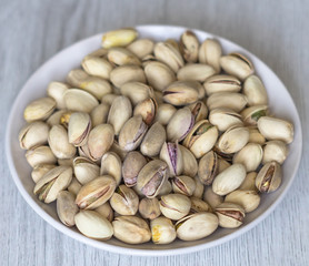 Healthy food  for background image close up pistachios nuts. Texture on white grey table top view. Nuts pistachio on the cup plate