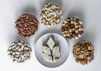  Oriental dessert halva with pistachio, almond, cashew nuts, peanut, walnut  on a  plate. Image. Healthy food. Nuts mix assortment. sweets, Turkish Delight. Isolated  background.. Eastern delicacy