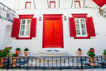 front of house with red windows on island mykonos in greece © IBRESTER