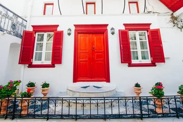 Fototapeten Mediterranes Europa front of house with red windows on island mykonos in greece  © IBRESTER