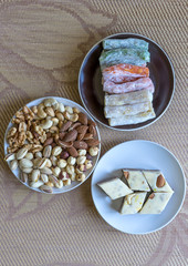 Traditional Turkish Delight. Oriental dessert halva on a  plate. Isolated on background. Eastern delicacy sweets. Healthy food. Nuts mix assortment. image close up nuts, pistachios, almond, cashew nut