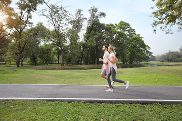 a runner caucasian couple is jogging in the park during summer season (healthy or sport concept)