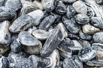 Black and white stones background.  Natural background from a gray stones of a rough structure. 