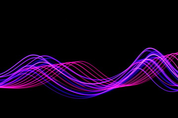 Long exposure, light painting photography.  An abstract wave of vibrant neon pink and purple color against a black background.