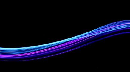 Long exposure, light painting photography.  Vibrant waves of electric blue and neon pink color against a black background.