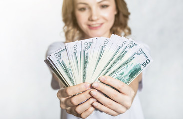 Happy young smiling woman hold us dollar money in hand over white background.