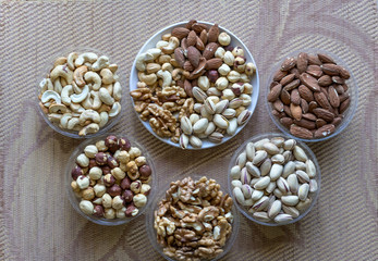 Fototapeta na wymiar Healthy food. Nuts mix assortment on texture top view. Collection of different legumes for background image close up nuts, pistachios, almond, cashew nuts, peanut, walnut. image