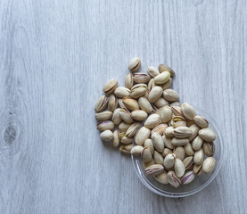 Healthy food  for background image close up pistachios nuts. Texture on white grey table top view. Nuts pistachio on the cup plate