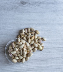 Healthy food  for background image close up pistachios nuts. Texture on white grey table top view. Nuts pistachio on the cup plate