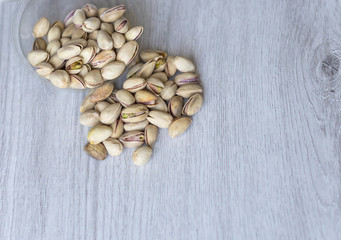 Healthy food  for background image close up pistachios nuts. Texture on white grey table top view. Nuts pistachio on the cup plate
