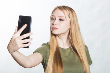 Beautiful young woman taking selfie on smartphone.