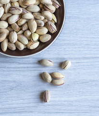 Healthy food  for background image close up pistachios nuts. Texture on white grey table top view. Nuts pistachio on the cup plate