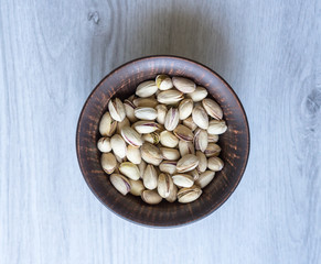 Healthy food  for background image close up pistachios nuts. Texture on white grey table top view. Nuts pistachio on the cup plate