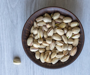 Healthy food  for background image close up pistachios nuts. Texture on white grey table top view. Nuts pistachio on the cup plate