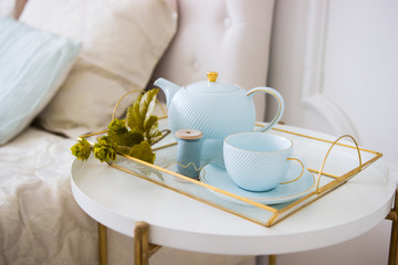 Warm knitted sweater,cup of hot tea with lavander on tray in bed
