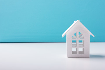 White wooden toy house on a blue background
