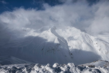 The sun, clouds and fog in Alpine Ski Resort And Ski Slopes in Winter, Livigno, Italy
