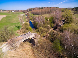 Destroyed railway bridge over Sapina river, Kruklanki town in the background, Poland (former...