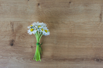 Top view of a bunch or bouquet of blooming white daisies on a wooden background. Hello spring or floral spring background