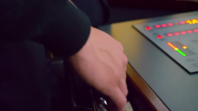 Close of a merchant marine students hands steering in a ship simulator