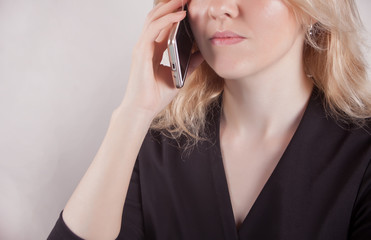 Fototapeta premium Young beautiful business woman holding phone and talk in the office.