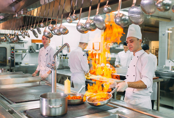 Modern kitchen. Cooks prepare meals on the stove in the kitchen of the restaurant or hotel. The...