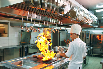 Modern kitchen. Cooks prepare meals on the stove in the kitchen of the restaurant or hotel. The...