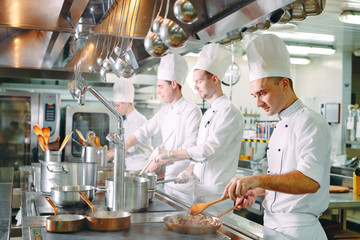 Modern kitchen. Cooks prepare meals on the stove in the kitchen of the restaurant or hotel. The fire in the kitchen.