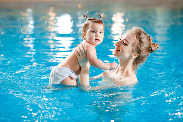 Mom and baby swim in the pool.