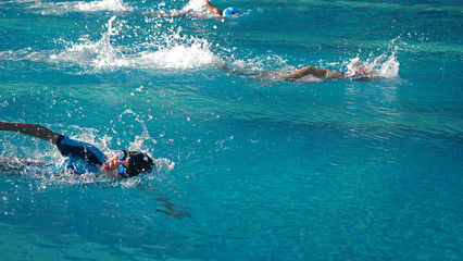 Asian boy swimming in the competition with warm sunlight from the left side.Selected focus. Wide...