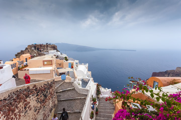 View of byzantine castle ruins in the colorful village of Oia