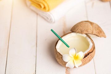 Coconut, spa products, coffee scrub, towels and seashells on white background