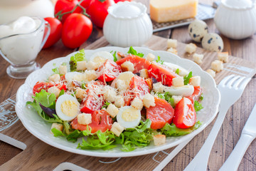 Caesar salad with red fish on the wooden table, horizontal