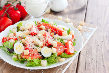 Caesar salad with salted salmon on a white plate, horizontal, copy space