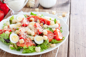 Caesar salad with salted salmon on a white plate, horizontal, copy space