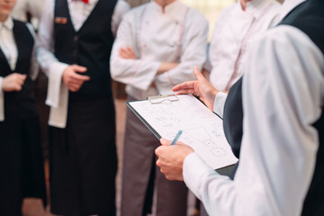 restaurant manager and his staff in kitchen. interacting to head chef in commercial kitchen.